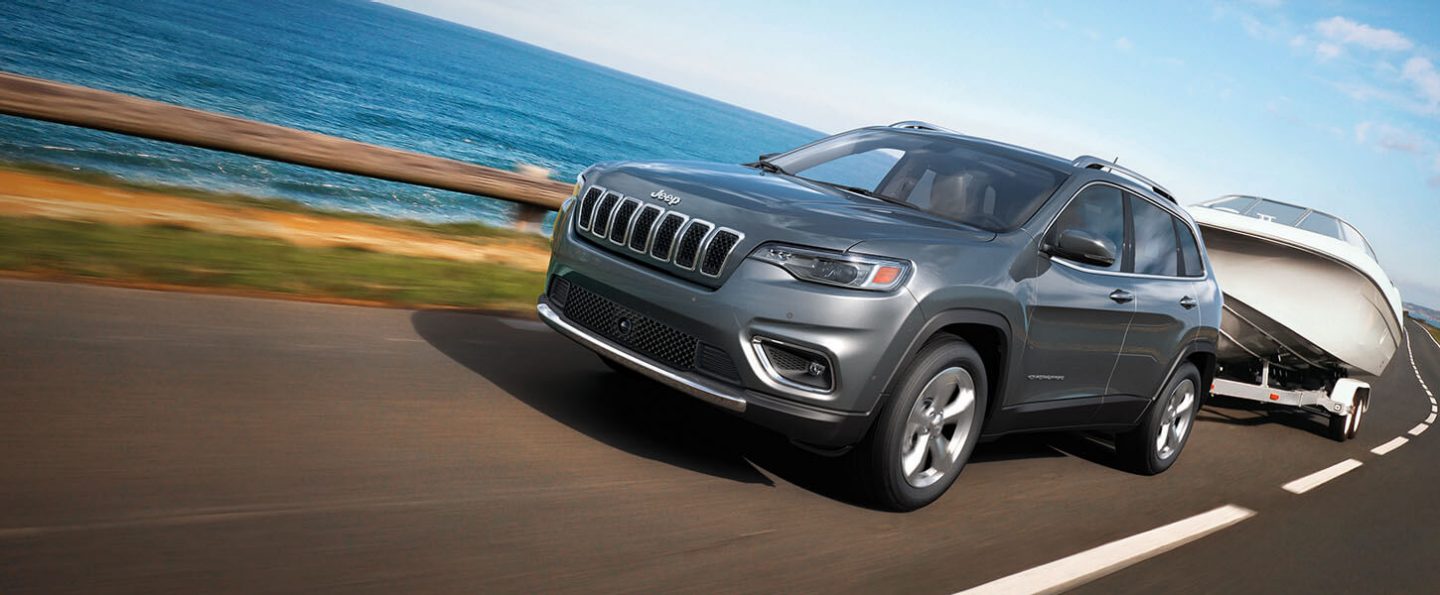 The 2021 Jeep Cherokee towing a boat.