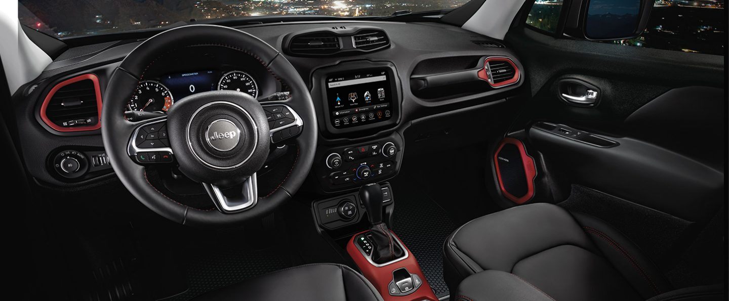 The front seats and red center console with transmission shifter on the 2021 Jeep Renegade, viewed from above.